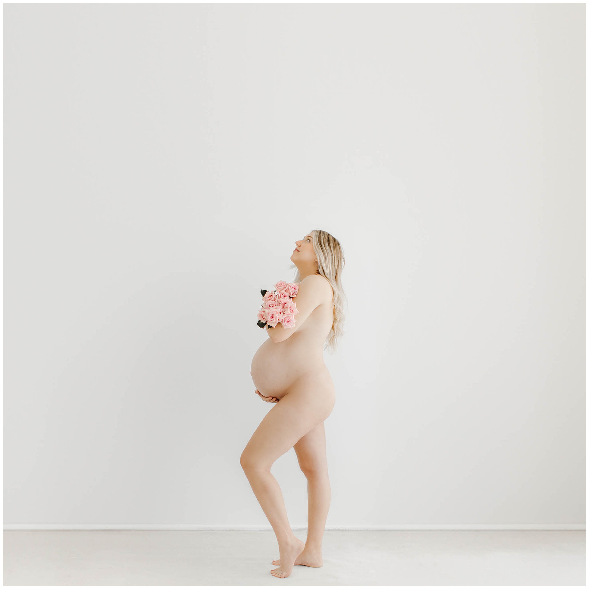 Artistic boudoir maternity photoshoot in Mackay showing a side profile maternity pose with floral styling and natural light.